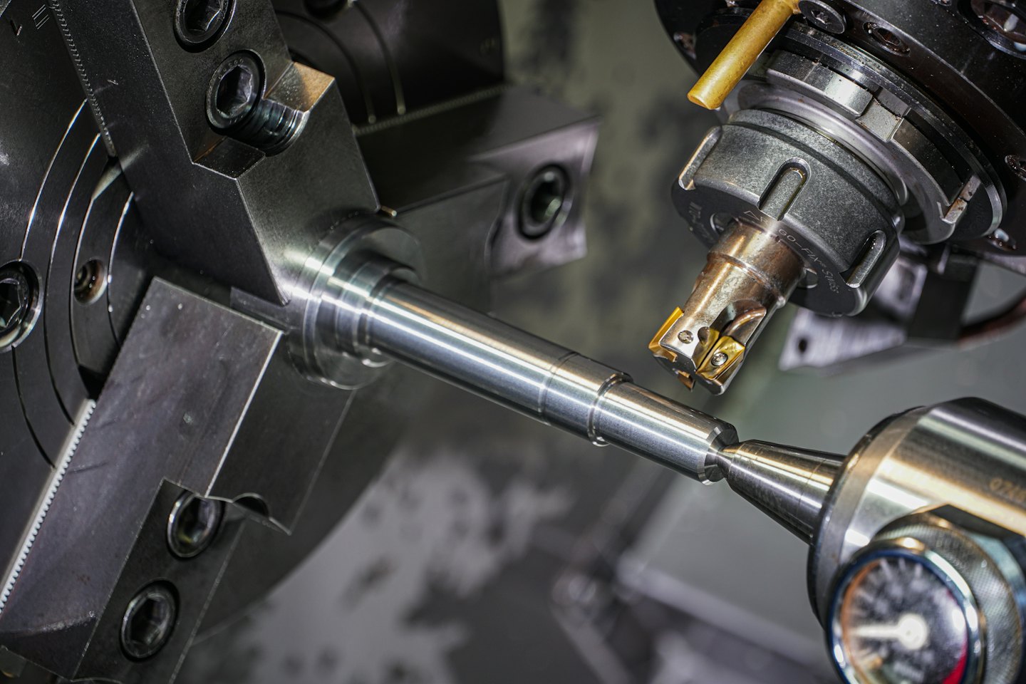 Kesici aletle gümüş metal çubuğu şekillendiren CNC makinesi.